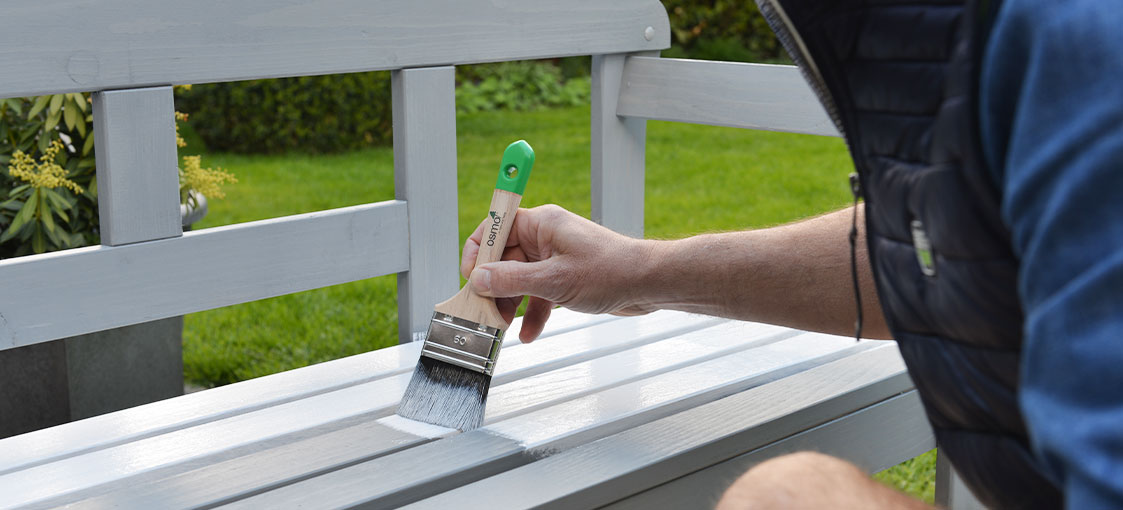 Instructions Osmo pour le bricolage : après un Séchage de 12 heures, appliquez en couche fine sur le banc la peinture Osmo Peinture de Campagne 2101 Blanc ou une autre couleur claire.