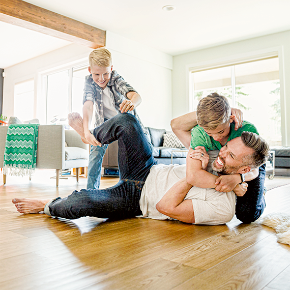 Un père et ses deux enfants jouent dans le salon